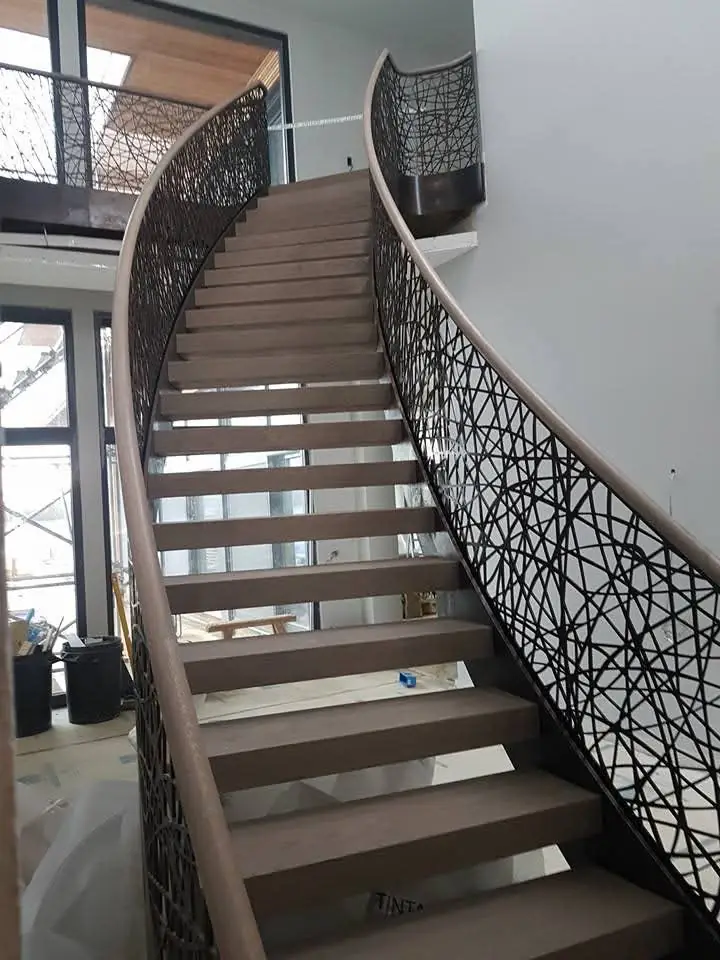 Schody gięte z ażurową balustradą